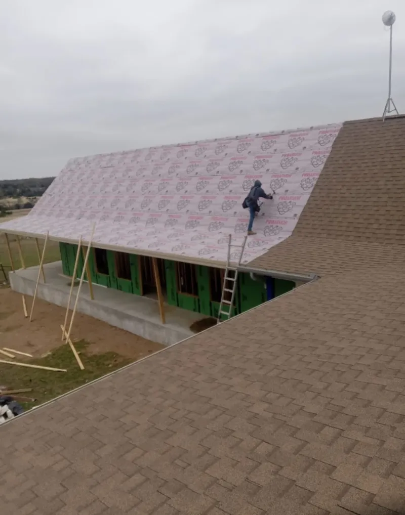 Worker preparing underlayment for a metal roof installation in Burbank